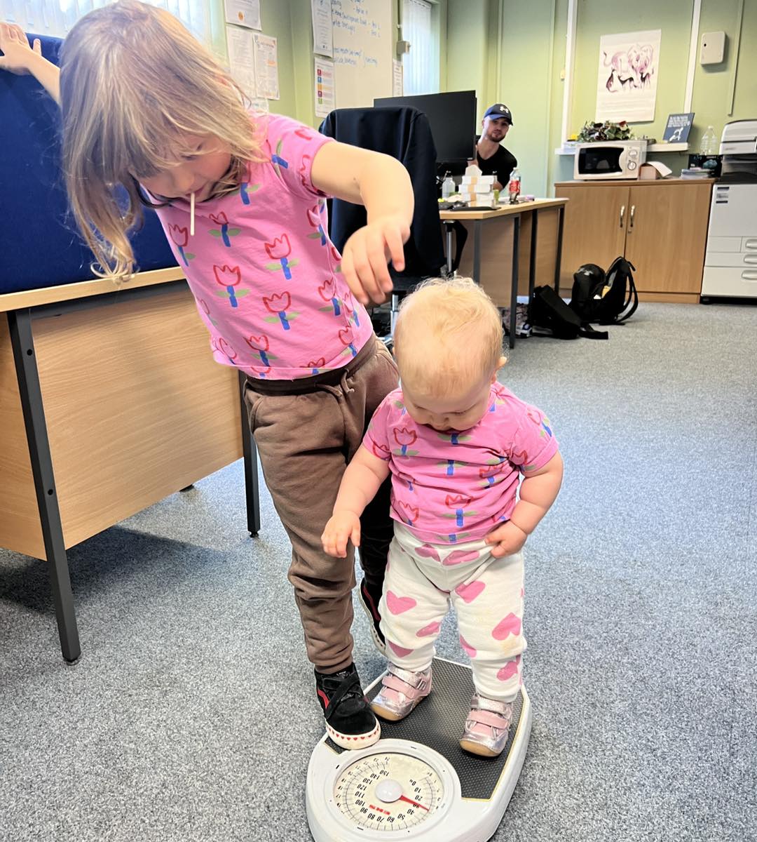 The 2 children stood on a weighing scale