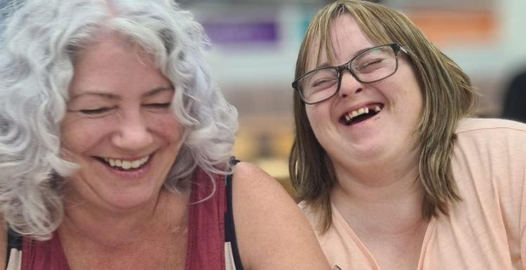 Older Woman sat with a girl with special needs