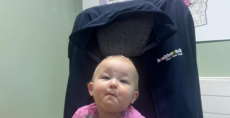 Healthwatch's youngest volunteer, toddler sat in a chair in the Healthwatch Wigan And Leigh office