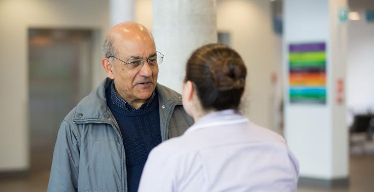 Man speaking to someone working in a health centre