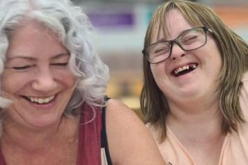 Older Woman sat with a girl with special needs