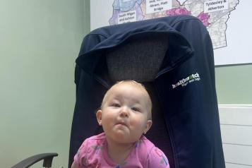 Healthwatch's youngest volunteer, toddler sat in a chair in the Healthwatch Wigan And Leigh office