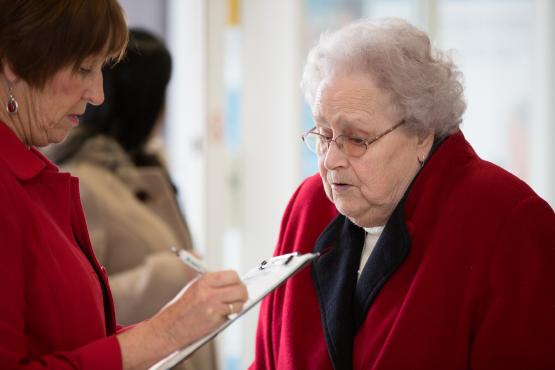 elderly woman completing a questionnaire 